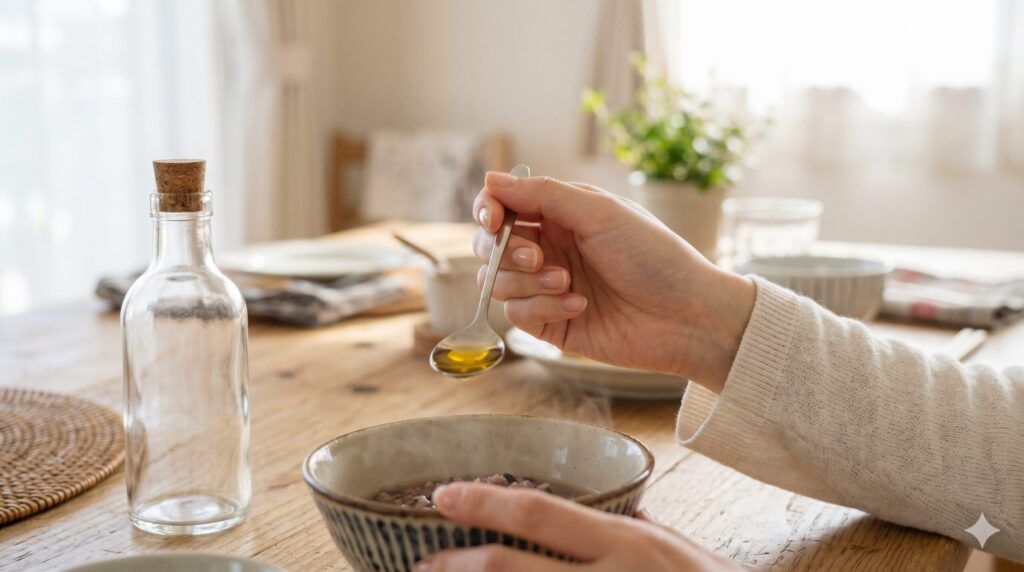小さじ1杯の油を手に、これで足りるだろうかと考えるような静かな手元のイメージ