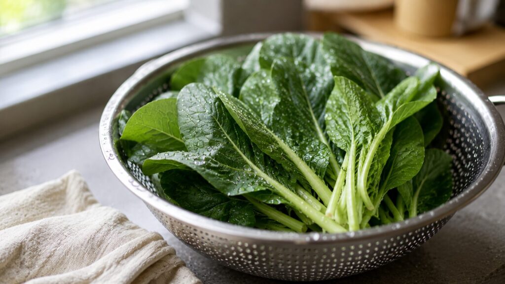 野菜の農薬が洗っても落ちない理由がわかる一枚。洗ったばかりの小松菜やほうれん草の葉に、水が玉のまま丸く残ってはじいている
