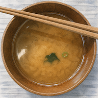ヴィーガンダイエットで塩分を抑えるため汁を残す習慣。具をあらかた食べて汁だけが残った味噌汁の椀を真上から接写した水彩イラスト