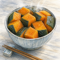 かぼちゃ100gでビタミンAの不足がちょうど埋まる。皮つきのかぼちゃの角切りが、小鉢のふちまでちょうど一杯に盛られている(水彩イラスト)