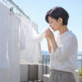 海へ…洗剤ですすぎ0回で洗ったシャツの匂いを干しながら確かめる女性