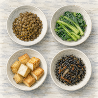 鉄が足りないと、動く力と考える力も落ちる。鉄を含む植物性の食品を4つの小皿に分けて真上から並べた(水彩イラスト)