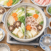 ヴィーガンと家族の食事の鍋料理。仕切りのある鍋の両側で白菜や豆腐、きのこを昆布だしで煮て、右側にだけ豚肉を入れている様子を真上から見た水彩イラスト