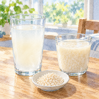 こうじ水の味は甘酒より甘さ控えめで爽やか。さらりと薄いこうじ水と、とろりと濃い甘酒のグラスを並べた水彩イラスト