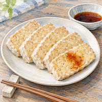 テンペは味付けなしだと味が薄く感じる。白い皿に並べた薄切りのテンペと、ひと切れにかけたポン酢の小皿の水彩イラスト